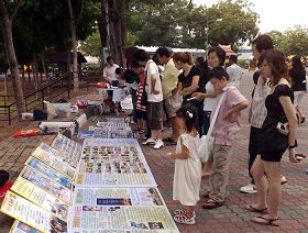 遊客在觀看展板，簽名譴責中共迫害