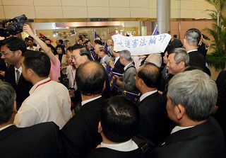 黃華華所帶領的廣東團一出海關，即面對法輪功學員在桃園機場大廳打出「法輪大法　真善忍」、「停止迫害法輪功」等橫幅。