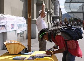 瑞士首都伯爾尼火車站廣場上，路人簽名聲援法輪功反迫害