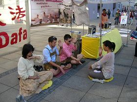 '身穿巴伐利亞傳統服裝的兩位小伙子，正跟著法輪功學員煉習功法。'