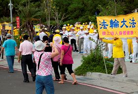 學員為數十車中國大陸來西子灣的遊客展演法輪功祥和優美的五套功法