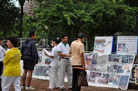 '遊人觀看法輪功真相展板'