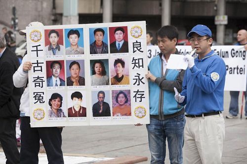 圖2：郭居峰（右）在德國科隆講述中共迫害法輪功真相，展板中他認識的十二名法輪功學員全部在迫害中失去了生命。