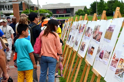 在自由鐘廣場，大批中、西方遊客認真閱讀講述法輪功真相的展板和圖片。