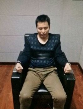 楊中省被銬在椅子上