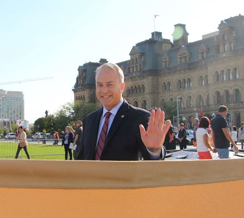 '圖3：McCauley來到法輪功學員煉功場地，向學員們揮手致意。'