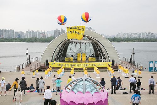 '圖1：5月13日，韓國部份法輪功學員和市民們匯聚在汝矣島漢江公園，歡慶第18屆「世界法輪大法日」及法輪大法洪傳25週年。'