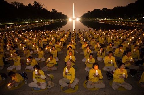 '圖1：二零一七年七月二十日晚，來自美東地區的部份法輪功學員在美國首都華盛頓林肯紀念堂前點燃燭光，悼念過去十八年來被中共迫害致死的同修，呼籲立即停止迫害。'