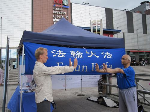 '圖9：感興趣的民眾（右）學煉功法'