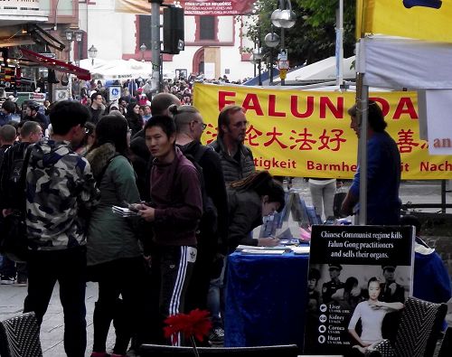 '圖2：法輪功的展台前人流穿梭不息，他們拿走資料，在反迫害的表上簽名'