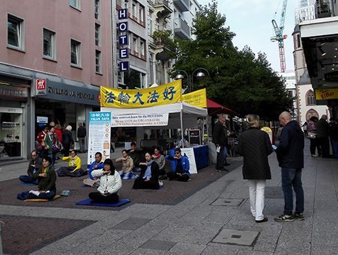 '圖3：法輪功學員在展位上煉功'