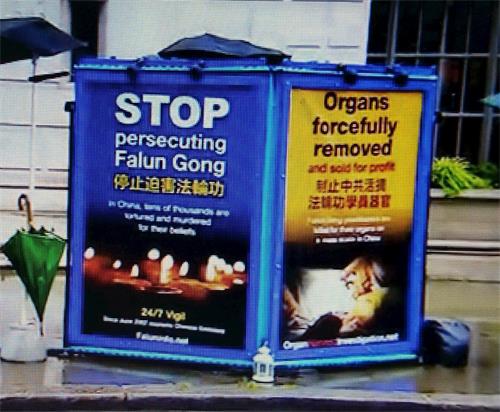 '圖7：BBC播出鏡頭中出現法輪功學員在倫敦中使館前堅持和平抗議的真相展板'
