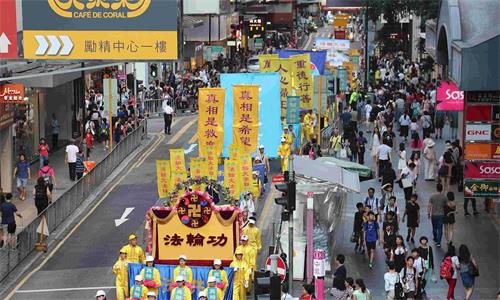 '圖12：慶祝世界法輪大法日的遊行陣列，在中環鬧市行進。'