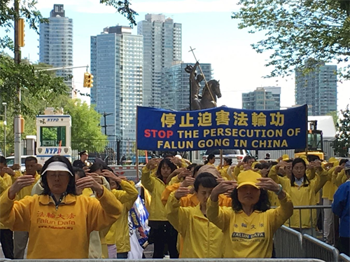 '圖1：在聯合國大會第七十三屆會議期間，法輪功學員在紐約曼哈頓第二大道47街的聯合國公園裏，冒雨和平抗議，呼籲制止中共迫害法輪功。'