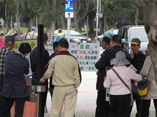 '圖2：中國大陸遊客觀看法輪功真相展板，聆聽學員講真相。'