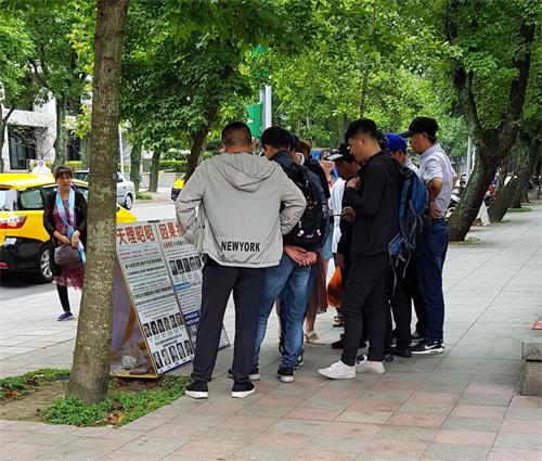 '圖：法輪功學員在台北國父紀念館的園區內的真相點吸引大陸遊客了解真相'