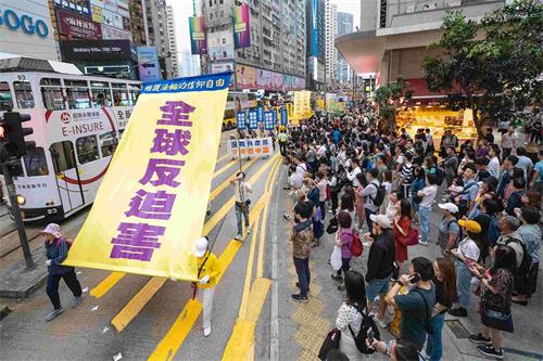 '圖11：遊行隊伍展示大型幡旗，呼籲全球反迫害。'