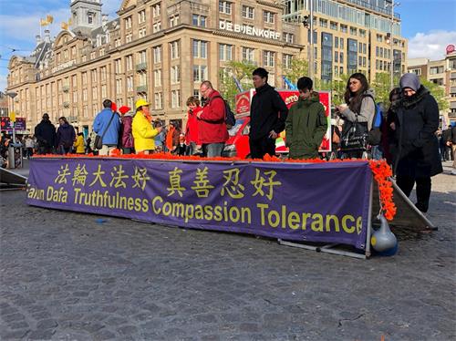 '圖1～2：荷蘭國王日，法輪功學員在首都阿姆斯特丹（Amsterdam）市中心──達姆（Dam）廣場傳播真相。'