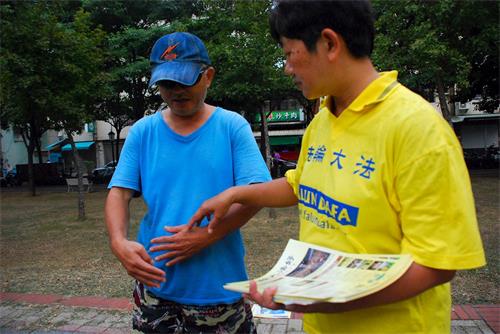 '圖8：文化公園裏，一位市民認真觀看功法展示，他現場學功，後來還參加了九天學法煉功班。'