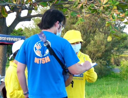 '圖5：法輪功學員向民眾傳遞真相，人們簽名聲援法輪功反迫害。'