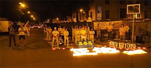 '圖11~12:在中共大使館前,學員們舉行燭光悼念被中共迫害致死的同修,寄託哀思'