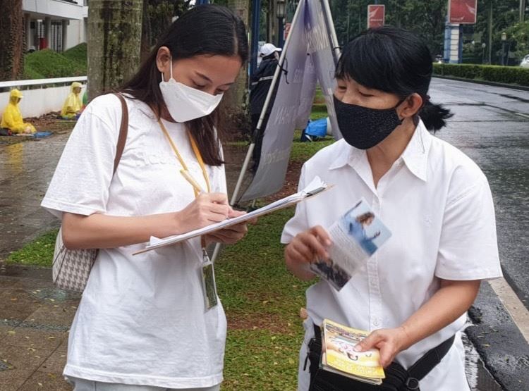 '圖2~4:二零二二年七月二十三日,印尼法輪功學員向民眾傳播法輪功的真相,徵集簽名呼籲停止迫害。了解真相的民眾紛紛簽名支持制止迫害。'